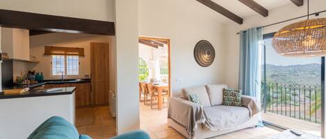 A spacious living area with a sofa, a coffee table, and a view of the outdoors.