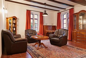Classic living room with a leather sofa, armchair, and wooden cabinet.
