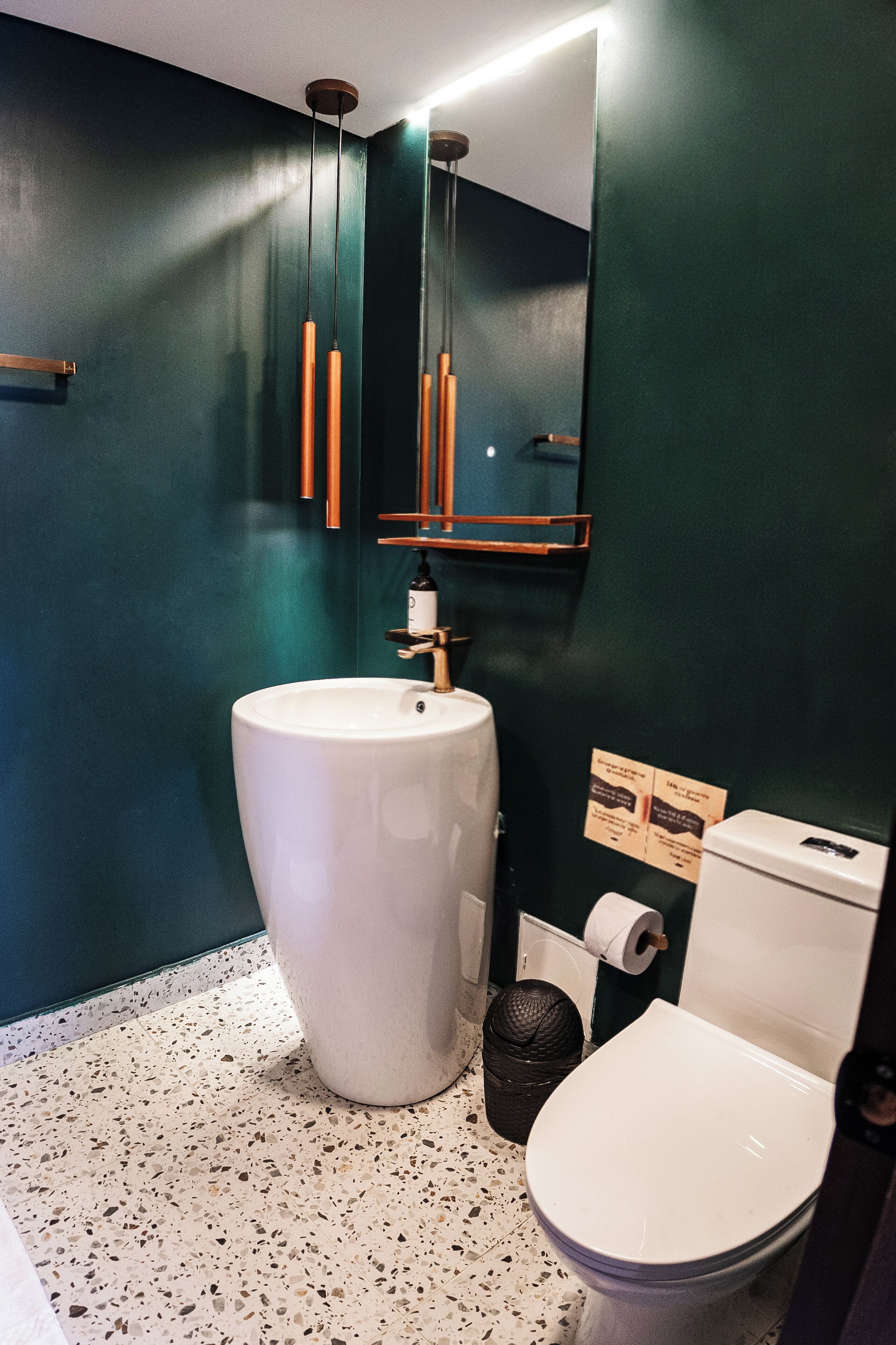 A bathroom with a white sink, a toilet, and a mirror.