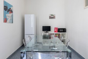 A small kitchenette with a refrigerator, microwave, and a TV on a shelf. - Alessandrini Apartment alla Finestrella by Wonderful Italy (Bologna)