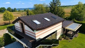 Ein modernes Haus mit Flachdach, großen Fenstern und einem Balkon.