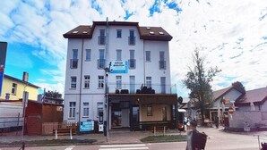 A multi-story building with a sign for 'pokój gosczenia' indicating a guest room. - Comfortable apartment with a sea view (Ustronie Morskie)