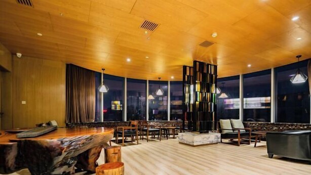 A modern interior with a wooden ceiling, large windows, and a central seating area with a table and chairs. - Xi'an Peace Arch Hotel (Xi'an)