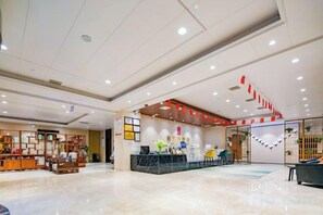 A hotel lobby with a reception desk, seating area, and a display of local crafts. - Xi'an Peace Arch Hotel (Xi'an)