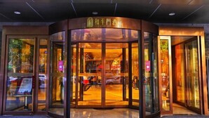 A hotel entrance with a revolving door and glass doors. - Xi'an Peace Arch Hotel (Xi'an)
