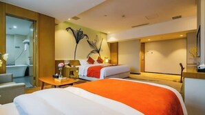 A hotel room with a bed, a desk, a chair, a bathroom, and a large wall art piece. - Xi'an Peace Arch Hotel (Xi'an)