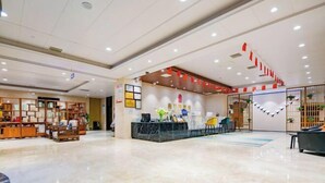 A hotel lobby with a reception desk, seating area, and a display of framed pictures. - Xi'an Peace Arch Hotel (Xi'an)