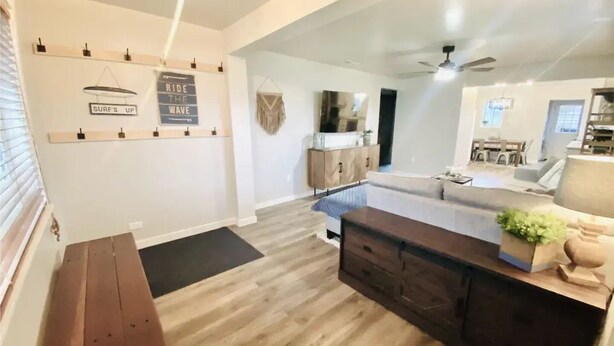 A modern living room with a wooden bench, a dark wooden coffee table, and a sofa. There is a kitchen area visible in the background with a dining table and chairs. - Cascade Basecamp: close to fun! (Cascade)