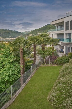Situated on a sloped terrain, this property offers a tranquil view of lush greenery and distant hills.