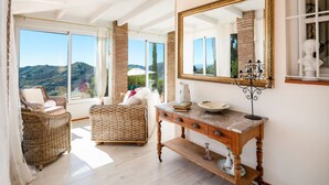 Une pièce meublée de meubles en osier, avec une console en bois et un grand miroir.