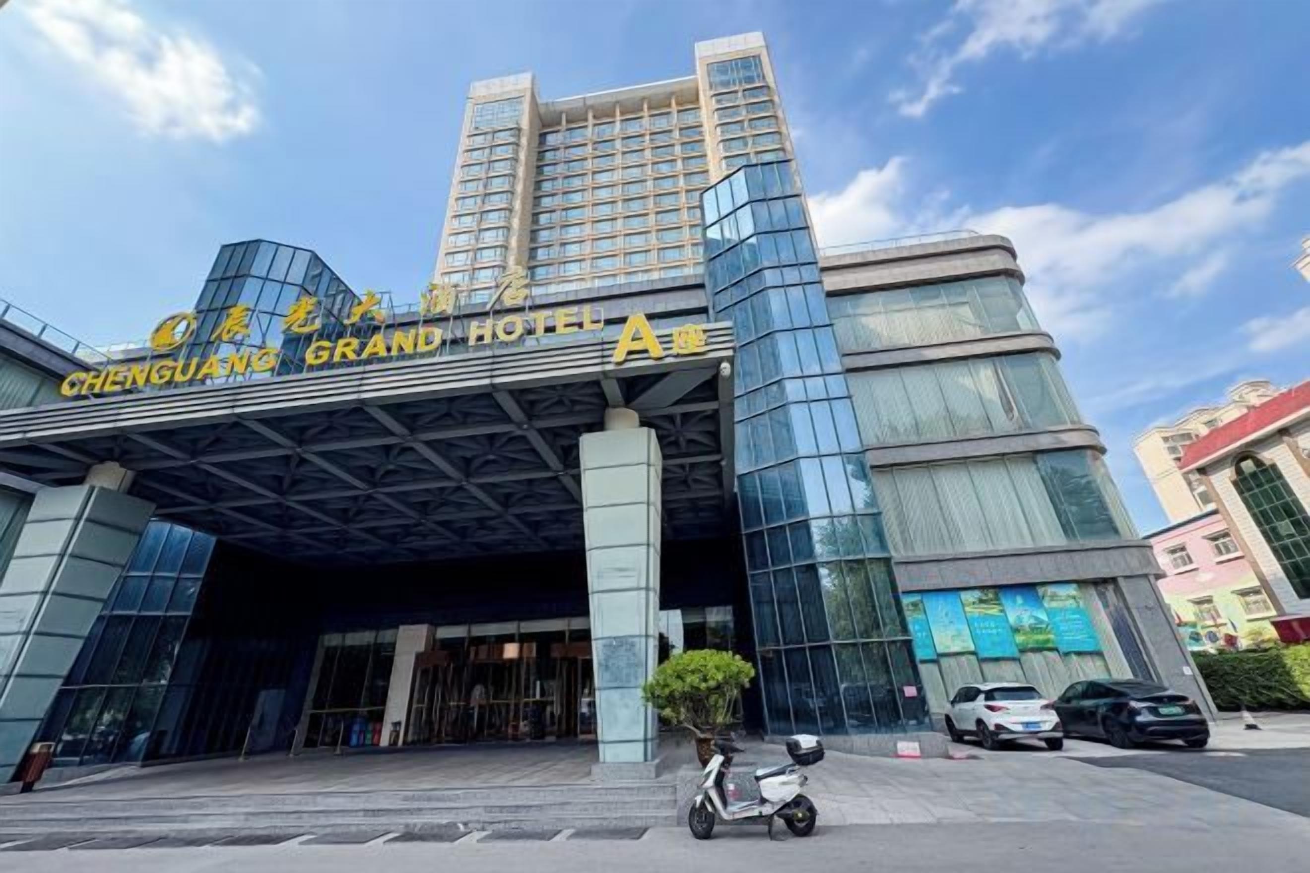A modern hotel entrance with a glass facade and a prominent sign.