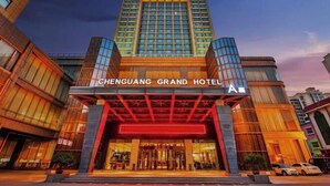 El exterior del Hotel Chenguang Grand, con una entrada destacada y un diseño arquitectónico moderno.