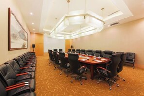 A conference room with a long table, multiple chairs, and a carpeted floor. - Chenguang Hotel (Xingtai)