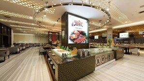 Un restaurante moderno con mostrador central, zona de estar y techo decorativo.