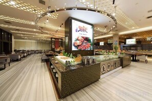 A hotel lobby with a central reception desk, seating area, and a large digital screen. - Chenguang Hotel (Xingtai)