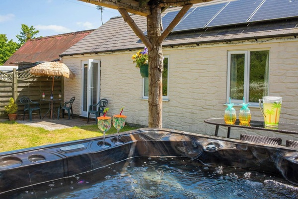 French doors leading from cottage to garden and hot tub area