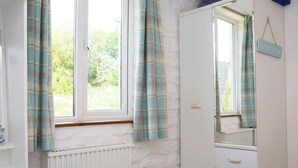 A bedroom with a window, a radiator, a wardrobe, and a bed. - The Old Cottage, Aberporth (Glanrhyd)