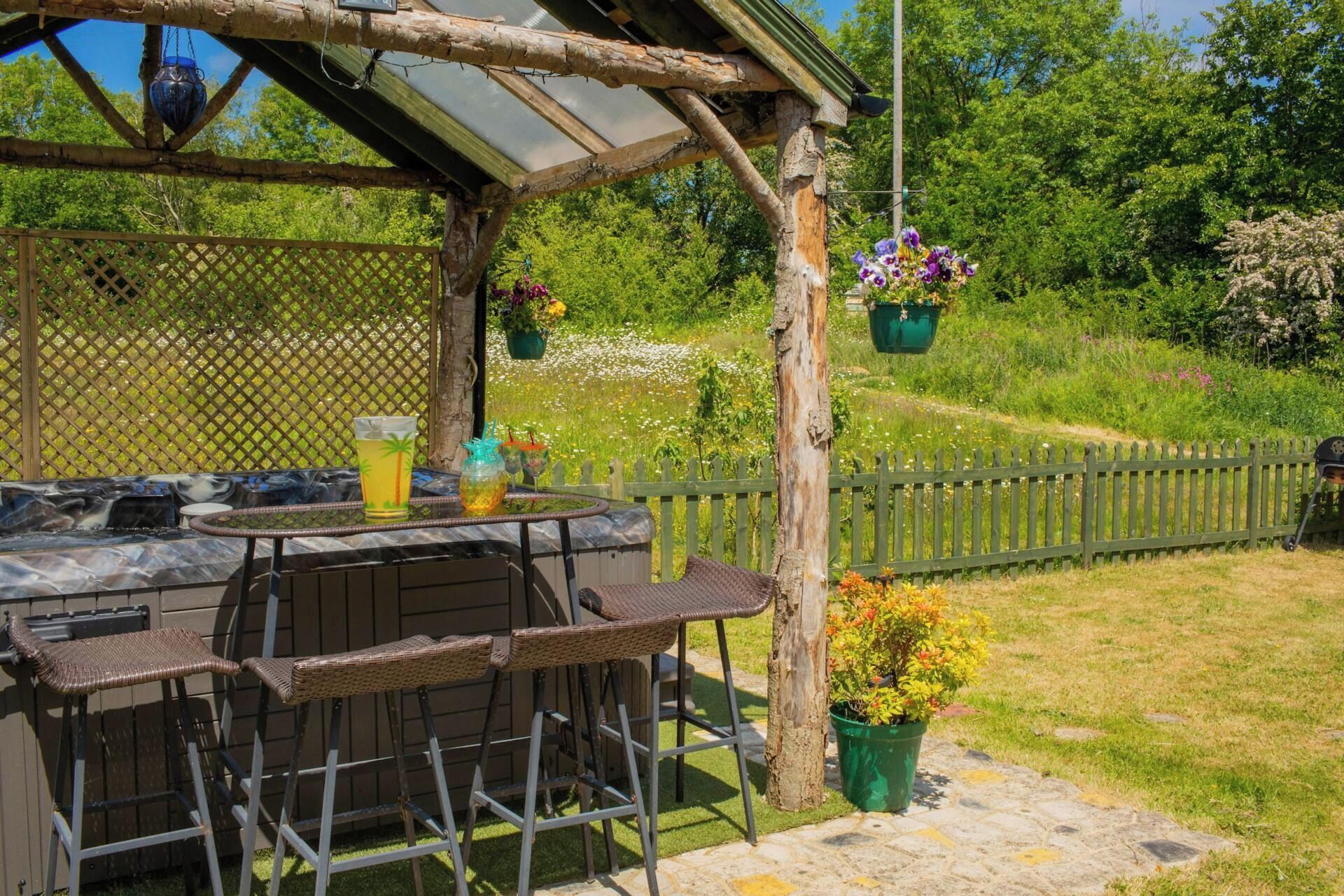 An outdoor patio with a table, chairs, and hanging planters.