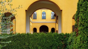 A yellow building with an arched entrance and multiple windows. - Medel (Appiano Gentile)