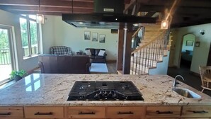 A kitchen with a central island, wooden cabinets, and a stove. - Peaceful Meadows

 (Dundee)