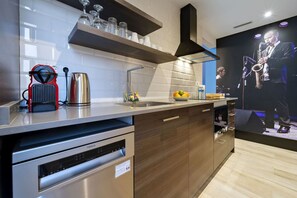 Una cuina moderna amb rentaplats, bullidor i màquina de cafè express incorporada.