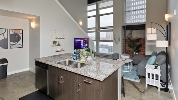 A modern kitchen with granite countertops, a dishwasher, and a large window. - Modern Oasis: 2-Story Loft, 2bd/2bth Downtown (Des Moines)