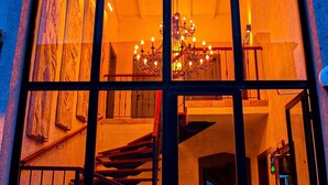 Un edificio con un'ampia finestra ad arco che mostra una scala e un lampadario all'interno.
