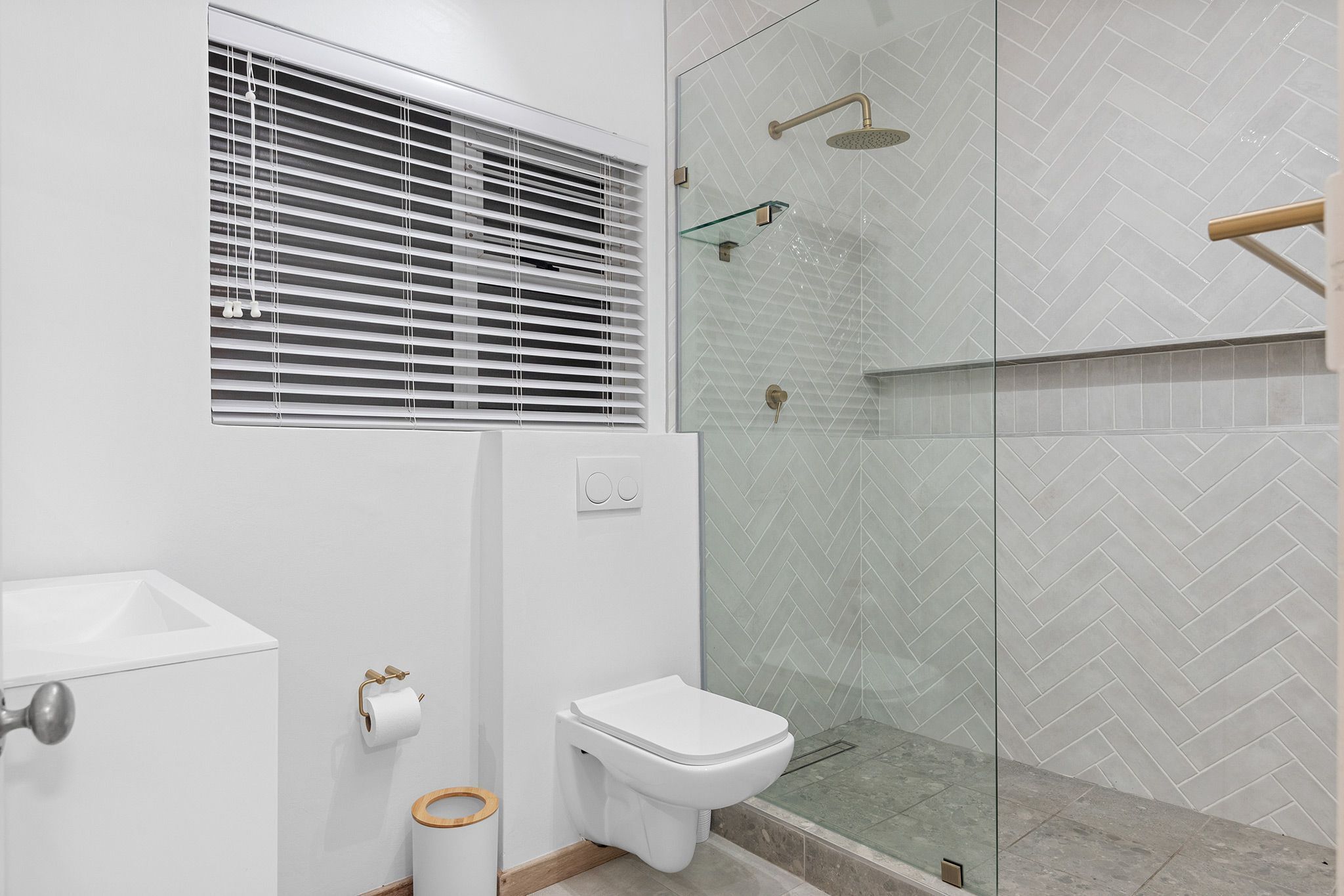 A modern bathroom with a toilet, bidet, and shower area.