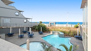A pool area with lounge chairs and a view of the ocean. - Perna Perna Coastal Escape (Durban)