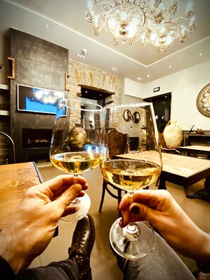 A modern living room with a fireplace, a television, and a chandelier. - Forvm Bijoux ROOMS (Trieste)