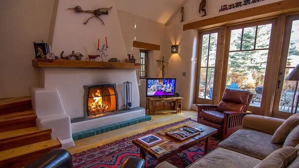 A cozy living room with a fireplace, leather furniture, and a television. - Caja de Tesoro ~ A Romantic Mountain Getaway! (Arroyo Seco)