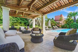 An outdoor patio area with wicker furniture, a pool, and lush greenery. - Mas de la Tour is an Idyllic property close to Beaches and St Tropez.  (Saint-Tropez)