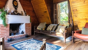 A cozy room with a fireplace, a sofa, and a wooden ceiling. - Natureza-piscina-lareira-Brazilan Corner (Aruja)