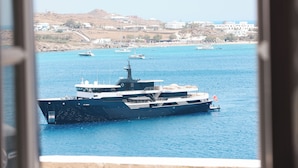 A large ship docked at a harbor with a view of a coastal town in the background. - Horizon 4 You Mykonos (Mykonos)