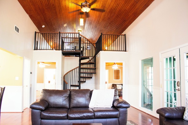 Main Cabin living area with 2 couches, stairs to loft with 3 twin beds