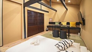 Un dormitorio con cama, armario de madera, sofá y televisor.