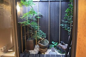 A traditional Japanese garden with a wooden fence, stone lanterns, and various plants. - Toki No Yado Kamishichiken: Max 4ppl, 2min to Sightseeing (Kyoto)