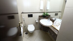 A bathroom with a toilet, sink, and mirror. - Naif Fort Hotel  (Dubai)