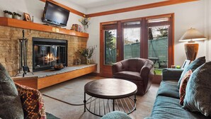 A cozy living room with a fireplace, comfortable seating, and a television. - The Charter at Beaver Creek C0405 (Beaver Creek)