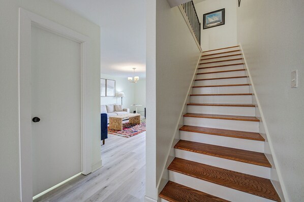 A staircase with wooden steps and a white wall.