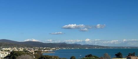 A coastal town with buildings, a clear blue sky, and a view of the sea.