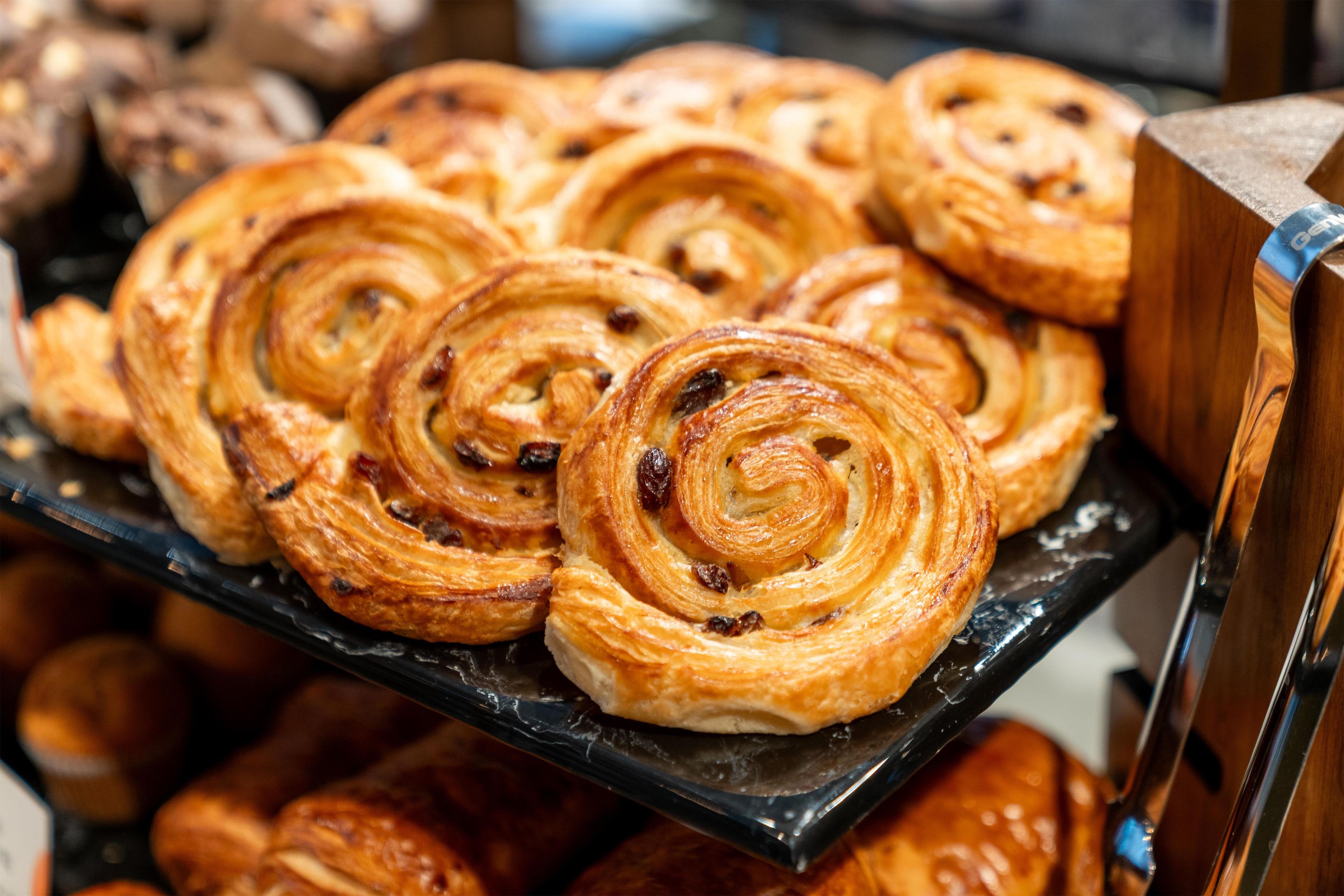 A display of pastries, specifically cinnamon rolls, arranged on a black tray.