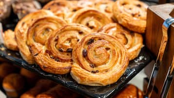 A display of pastries, specifically cinnamon rolls, arranged on a black tray.