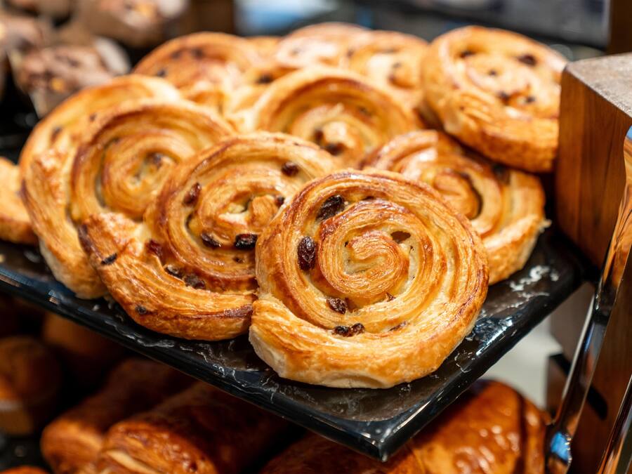 A display of pastries, specifically cinnamon rolls, arranged on a black tray.