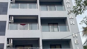 A multi-story building with balconies and air conditioning units. The building has a sign that reads "SAMRAT INN A Unit By Everest Inn". - Samrat Inn (Pune)