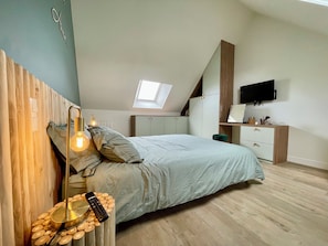 A bedroom with a bed, a desk, a TV, and a skylight. - « Les Tropiques» 4p, Proche Plage, Wifi, Tennis (Quiberon)