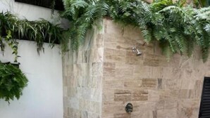 A spa area with a stone wall, a small pool, and a waterfall feature. - Casa Grande (Santo Domingo)