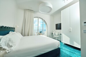 Relax in this serene room with a large bed, flat-screen TV, and balcony offering a view of the sky.