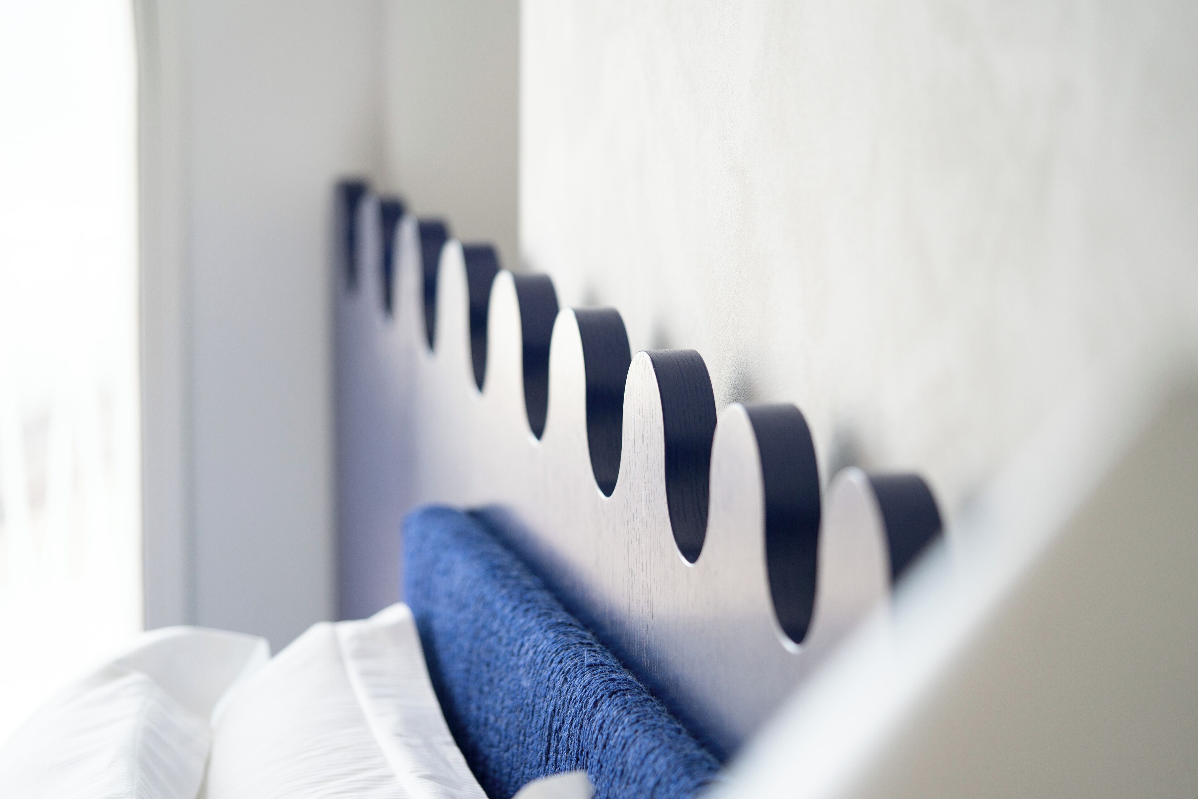 Un lit moderne doté d’une tête de lit ornée de motifs découpés.