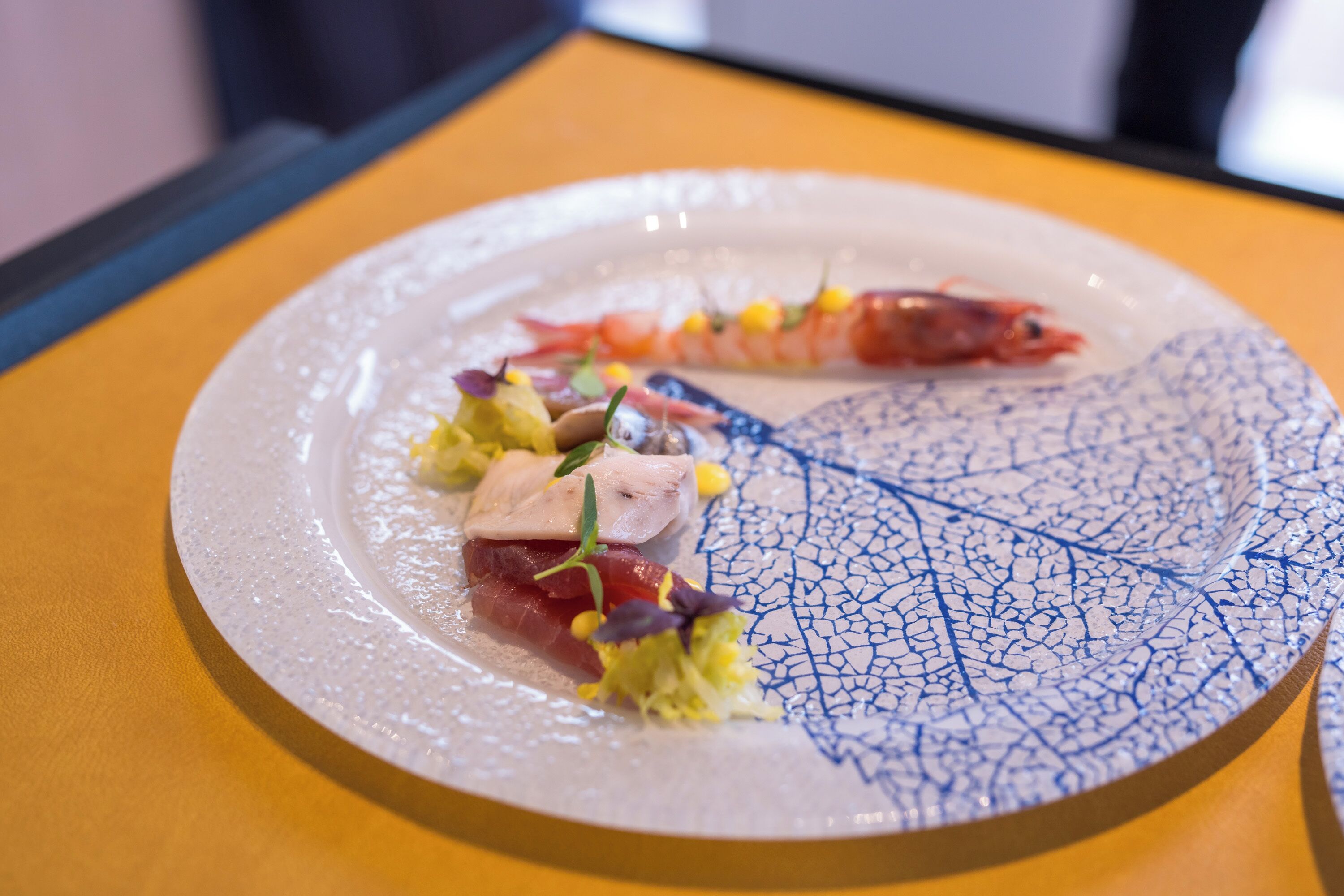 Une assiette remplie de différents plats, notamment un plat de poisson et quelques accompagnements.